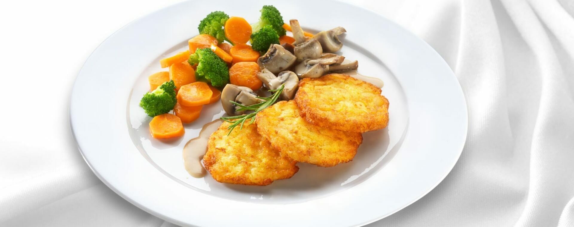 11er Crispy Rösti homemade style with creamy mushroom sauce served with broccoli and carrots